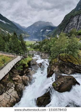 Scenic view of Geiranger valley and waterfall trail during cloudy summer day, Norway