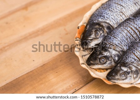fresh fish served on a plate on a wooden table