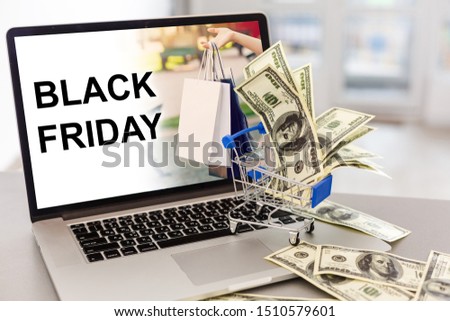 Online shopping concept. Small shopping cart on laptop keyboard Black friday advertisement in a laptop computer screen placed on a workplace