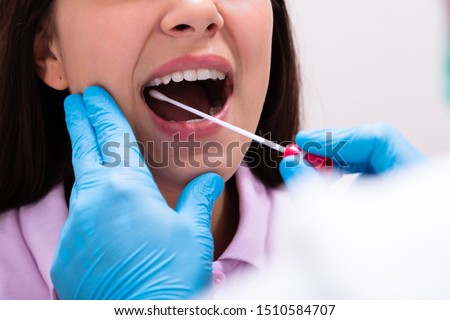 Rear View Of A Male Doctor Taking A Bodily Fluid Sample For DNA Test