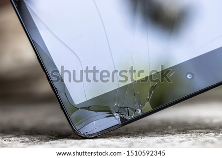 Closeup of cracked screen, the tablet slipped out of hand and laid on the street. Selective focus.