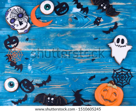 Halloween party decoration concept. Halloween gingerbread cookies on the blue wood background.