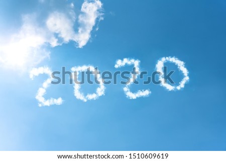 Numbers 2020 symbol inscription on a background of blue sky from white smoke of clouds lit by a bright sun