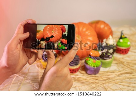 Man taking shot of Halloween decoration, food blog, Halloween cupcakes