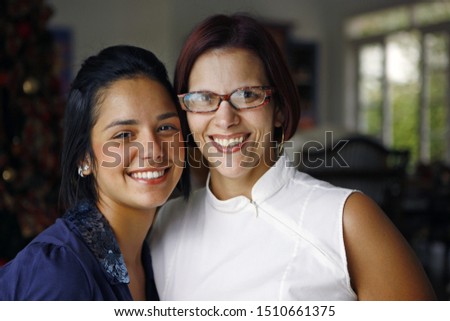beautiful brunette girl hugging her red-haired mother smilinggirl and her mother smiling