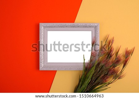 
white frame with a plant on a yellow and orange background