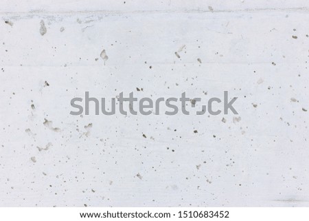 Concrete wall as gray coarse facade made of natural cement with holes and imperfections as an empty rustic texture background. Gray concrete wall coarse facade