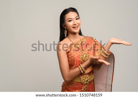 woman wearing Thai dress that made a hand symbol