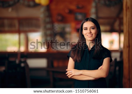Manager Standing in a Restaurant Welcoming Customers. Confident self-employed female entrepreneur greeting guests 