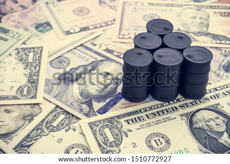 Spending or investment of a country's revenues from petroleum exports industry (Petrodollar). Oil barrels on US dollar banknotes. Concept of crude oil production, petroleum industry or petrodollar.