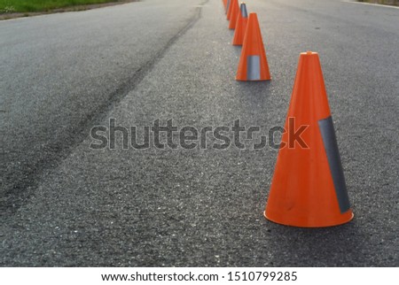 Photo of background with orange road cones on the pavement.