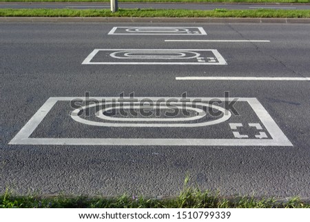 Photo of a background with road markings. Road sign warning drivers about photo and video recording of violations.