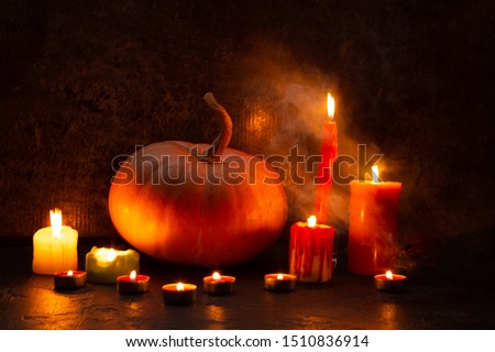 Pumpkin among burning candles. Halloween