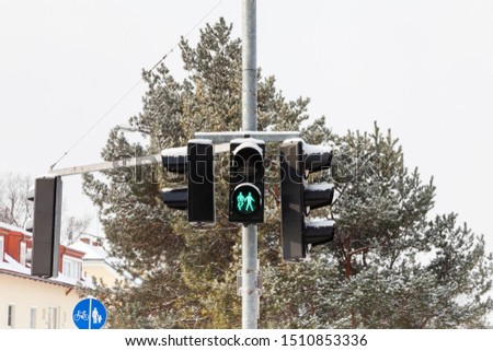 Pedestrian Crossing.  A snow covered green light is displayed on a pedestrian crossing in Salzburg, Austria.