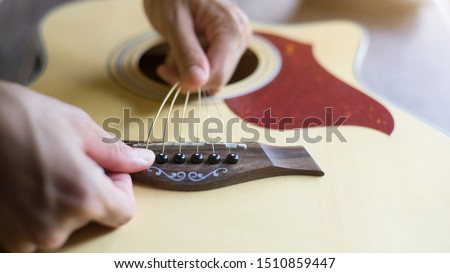 Change the acoustic guitar strings, 
Steps to insert all 6 guitar strings, Close-up Royalty-Free Stock Photo #1510859447