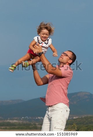  father and daughter playing in the mountains