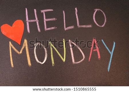 handwriting hello monday on chalkboard with colorful chalk and heart paper