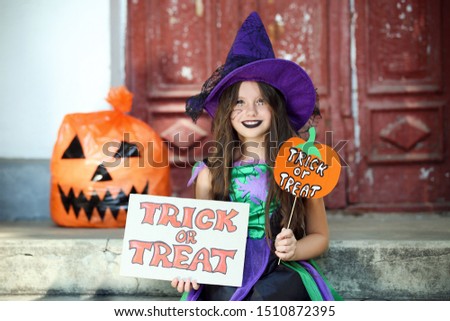 Beautiful girl in halloween costume sitting on porch and holding papers with text Trick or Treat