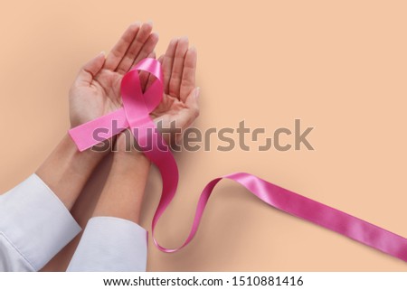 Woman holding pink ribbon on white background./Health care and cancer female concept.