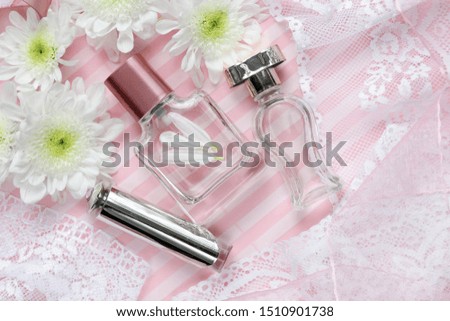 romantic composition. bottle of perfume on a pink background, flowers, lace and an envelope