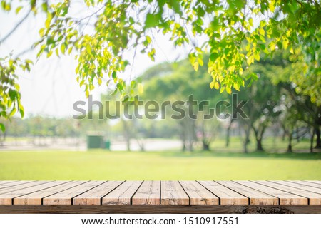 Empty wooden table with garden bokeh for a catering or food background with a country outdoor theme,Template mock up for display of product Royalty-Free Stock Photo #1510917551