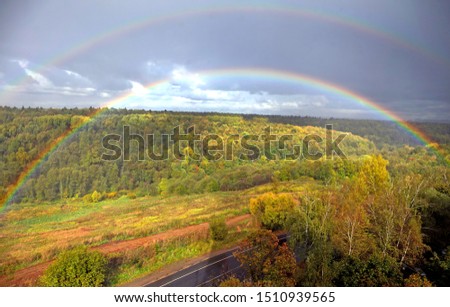 Rainbow after rain over autumn forest.