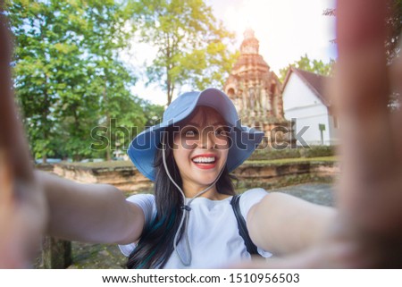 Close-up portrait of Beautiful Asian women walking to old temples and taking pictures of themselves via online media . She is a beautiful smile. Have fun and have clean teeth.