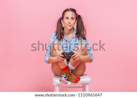 A girl with a gaming joystick on a pink background