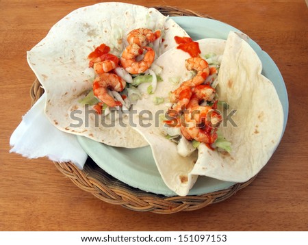 plate of shrimp tacos on a wooden table