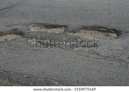 pit with sand and stones on the gray asphalt road