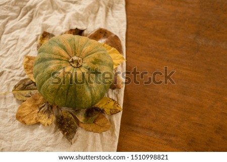 Top view of Autumn fallen leaves with Pumpkin on brawn wooden background. Thanksgiving day, Halloween concept. top view. Copy space for text. Cozy fall.
