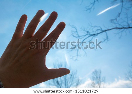 Open hand directed toward the sun protects against strong sunlight.