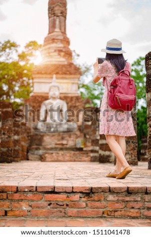 woman tourist enjoy riding local bicycle to see the historic park of Thailand, exciting takes photo to explore the wonderful place of sightseeing