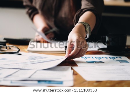 Business woman investment consultant analyzing company annual financial report balance sheet statement working with documents graphs. Concept picture of business, market, office, tax