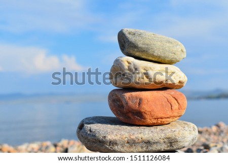 Stones meditation figures. Symbolical statue of several stones. Tradition to collect  stones in private. Beautiful water landscape background with natural stones.