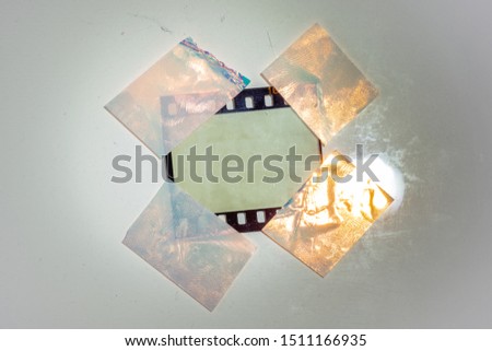 digital high res photo of blank 35mm film border or frame fixed on white background with 4 holo stickers, just blend in your photo here, cool poster picture placeholder, lamp shining on film material Royalty-Free Stock Photo #1511166935