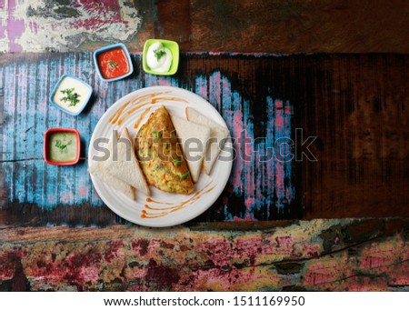 Crum chicken Tenders, Bred omelet, Crum chicken tender, egg Omelet served in white dish on wodden color texture with sauces.