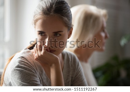 Offended millennial adult daughter and senior mother sit aside back to back avoid talking after fight, hurt stubborn two generations of women ignore each other after conflict, misunderstanding concept Royalty-Free Stock Photo #1511192267