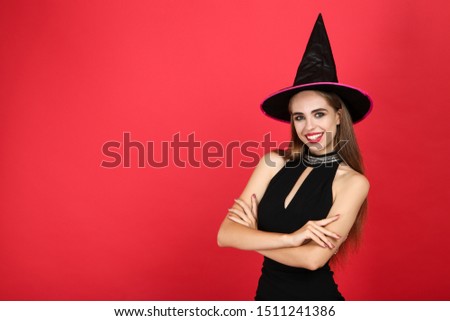 Beautiful woman in halloween costume on red background