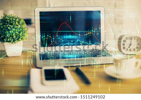 Double exposure of graph and financial info and work space with computer background. Concept of international online trading.