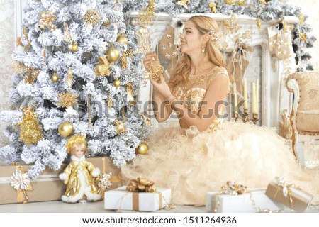 Portrait of young woman decorating Christmas tree