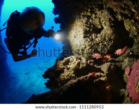 scuba diver is exploring and discovering caves underwater cave diving blue water