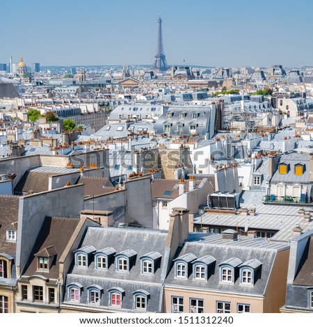 Paris, typical buildings and roofs in the Marais, aerial view from the Pompidou Center, with the Eiffel Tower in background 
