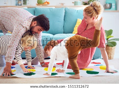 happy family having fun together, playing twister game at home