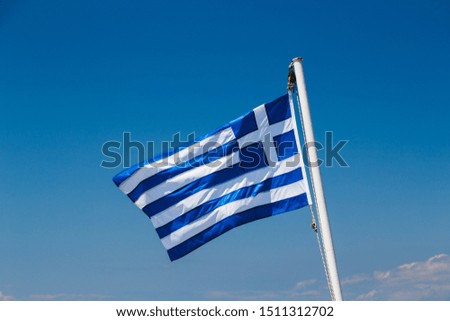 Greek flag on the blue sky background.