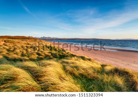 Windswept sand dunes at Big Sand Beach at Gairloch in the Highlands of Scotland with the Isle of Sye in the distance Royalty-Free Stock Photo #1511323394
