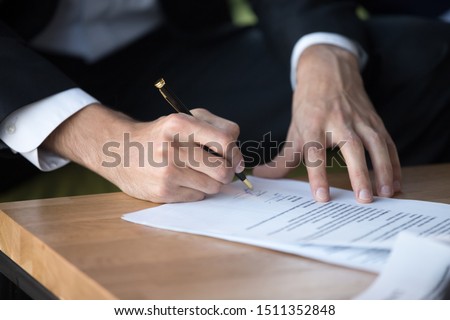 Close up businessman signing contract, partnership agreement after successful negotiation, making legal deal, putting signature, hiring process, candidate filling job agreement, good deal