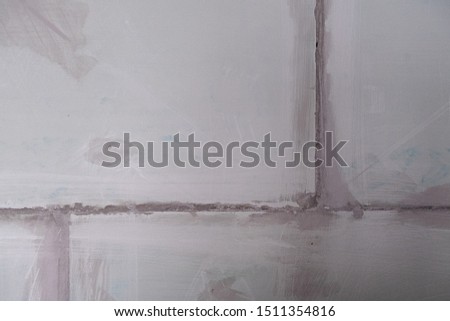 Abstract gray background. A wall of rough concrete blocks cemented together.