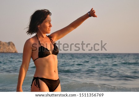beautiful young woman walks along the surf at sunset on the beach. relaxation vitality healthy lifestyle concept