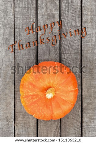 Beautiful smooth pumpkin orange on grey wooden background with space for lettering, copy space, for Halloween and thanksgiving day. For registration of recipes. It says Happy Thanksgiving